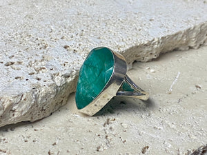 Our large facet cut emerald is set in a simple sterling silver bezel to show off the beauty and size of the stone, which is frankly huge. And it's a beautifully even, deep coloured stone as well. This is a statement ring that can be worn be either men or women. Measurements: Emerald 2.5 x 1.7 cm Size 8.5 | 18.75 mm