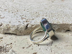 Our large facet cut emerald is set in a simple sterling silver bezel to show off the beauty and size of the stone, which is frankly huge. And it's a beautifully even, deep coloured stone as well. This is a statement ring that can be worn be either men or women. Measurements: Emerald 2.5 x 1.7 cm Size 8.5 | 18.75 mm