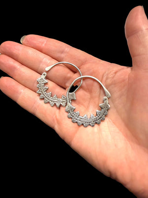 Berber open hoop earrings with ornamented crescent edged with trefoil projections. High grade silver. Tunisia. Early 20th C. Height 4.1 cm, width 3.7 cm