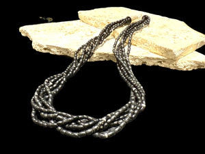 One of the oldest necklaces collected by Kashgar founder Bernie Heaphy, we've remade these strands into a very wearable multi strand necklace. Made by the Naga of northeast India, these black ceramic beads are teamed with sterling silver highlights and cone ends with hook clasp. Measurements: 57 cm length