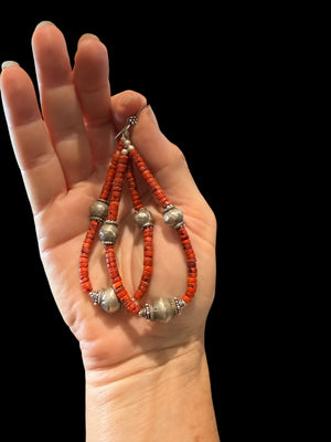 Long, bold southwest earrings of heshi coral highlighted with antique silver Rabari beads, sterling silver beads and hooks. Natural, sustainable bamboo coral, 10.5 cm length