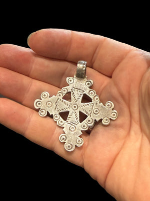 Mid 20th century round Ethiopian silver crucifix, cut from a Marie Therese silver thaler. Almost identical markings on both sides. Small amount of wear at the head of the bail. Height including bail 5.1 cm
