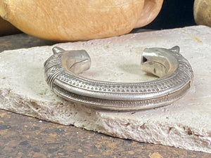 An antique silver cuff, with the ends shaped into the image of a lion's head. Circa early 1900's or earlier, high grade silver. Rajasthan or Himachal Pradesh, India. It has what is most likely the owners mark or initials engraved on it.