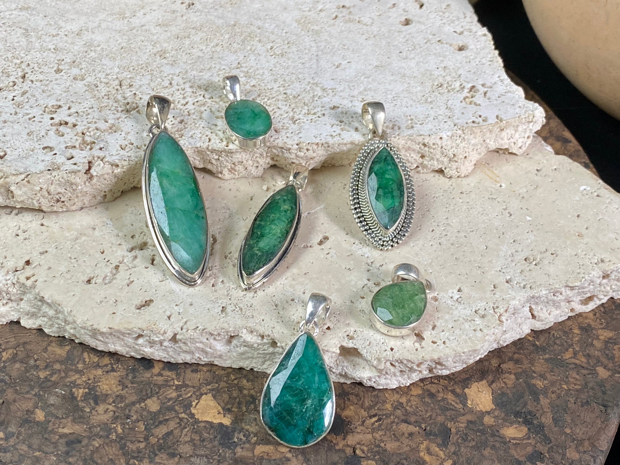Six lush natural emerald pendants featuring large facet cut stones set in sterling silver. All are set with generous bails to fit on even the largest of chains, torcs or cords. Ranging in length from 6 cm to 2.8 cm