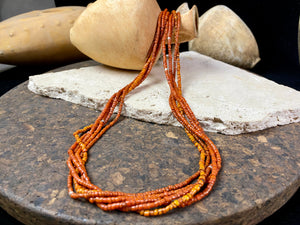 Our long tribal multistrand necklace is made with antique ceramic beads worn by the Bonda people of the Himalayas. This five strand red-brown-orange necklace is finished with a handmade sterling silver clasp and features sterling silver bead detailing. Measurements: 66 cm length