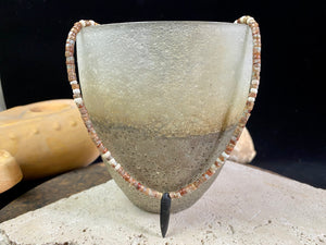 This unique necklace is made from heshi amazonite quartz druzy beads, highlighted with Kachin Burmese shell beads and a pendant made from unpolished onyx. Finished with sterling silver findings and hook clasp. Our necklace will look great on either men or women. Measurements: length including clasp 43.5 cm (17”)