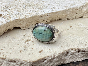This simple ring features a large antique cabochon turquoise stone, set in a simple patterned silver bezel, with an adjustable ring band. As is the case with many of the rings we are currently buying, the stone is old and has been reset into a new silver band. Measurements: Ring face 2 x 1.5 cm Inner diameter 16.5 mm | Size 6 , however the adjustable band will fit any finger sized 5 -7