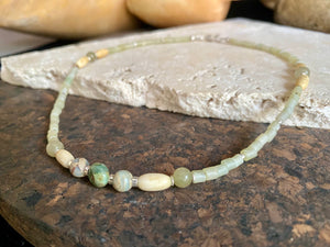This unique choker features beautiful vintage beads from the Kashgar collection - blue green turquoise centre bead, Ethiopian opal, Bone beads from Burma, Pale green chrysoprase beads, Green serpentine tube beads from Afghanistan and 925 sterling silver detailing and lobster clasp. Length 40.5 cm
