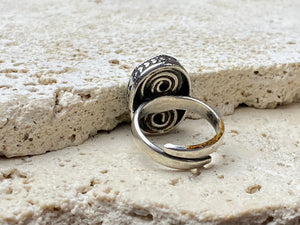 This simple ring features a large antique cabochon turquoise stone, set in a simple patterned silver bezel, with an adjustable ring band. As is the case with many of the rings we are currently buying, the stone is old and has been reset into a new silver band. Measurements: Ring face 2 x 1.5 cm Inner diameter 16.5 mm | Size 6 , however the adjustable band will fit any finger sized 5 -7