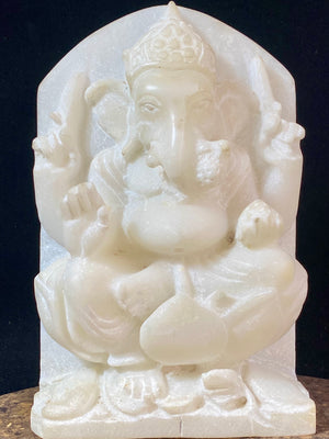 Hand carved marble stone statue of Ganesh. Our Ganesh sits on a lotus pedestal, while his mouse sits at his feet. One of his right hands is upraised in the gesture of protection, while the other holds his favourite ladoo sweet. Measurements: 22 cm high, 14 cm wide, 6 cm depth