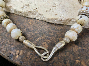This statement choker necklace inspires Boho chic and features large antique Naga shell beads beads, vintage Indian silver beads and a handmade sterling silver hook. The central bead is an old piece consisting of hand wrapped silver over a wood frame. Length 48 cm