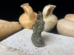 Kali with four arms, standing on Shiva, holding a curved sword, severed head and skull cup. Her fourth hand displays the gesture of blessing. She wears a garland of skulls around her neck and is covered by her long, wild, disheveled hair. This statue is approximately 80 years old (early 20th century). She has a fine and evenly dark patina. Measurements: height 7.3 cm, width 5 cm.