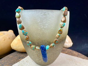 Our necklace is crafted from Tibetan turquoise with a central hand carved pendant of lapis lazuli. Finished with sterling silver beads and hook clasp. These beautiful natural stones range in colour from blue to blue-green. Length 42 cm