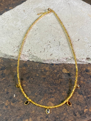 Vibrant gemstones adorn this elegant multi charm necklace. Plated 22k gold over brass, the multicoloured gemstones are evenly spaced and bezel-set to highlight the beauty of each gemstone. This necklace is designed to be worn short, but comes with an extension chain so you can set the length according to your neckline. Measurements: length 41 cm, with extension chain 45.5 cm