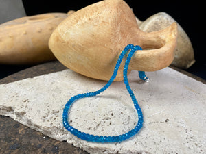 Short dark blue apatite necklace featuring graduated faceted apatite beads finished with a sterling silver lobster clasp. This is a lovely statement necklace that matches any skin tone or clothing. These stone are natural and not heat treated Measurements: 39.7 cm total length