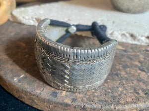 Antique bazuband bracelet, made up of interlocking components threaded onto cord with toggle closure. Early 20th century or earlier, high grade silver. This is an excellent example, and is a very collectible yet wearable piece of jewellery. Weight 94 grams. Inside circumference 21 cm. Height 4 cm, length 17 cm