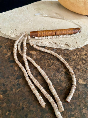 This is a vintage wood sewing needle case from northern Thailand, from the Ahka tribe. This beautiful, old and rare vintage piece is highly decorated and made from bamboo, etched, stained with red betel juice and finished with a long fringe of Jacob's tears. Length 24.5 cm with fringe, length of tube 9 cm