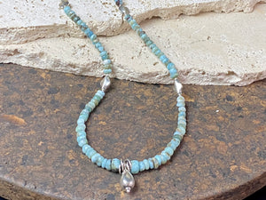 Light blue blue necklace of tumbled, facet cut graduated larimar, highlighted with Rajasthani silver beads and a beautiful central drop pendant. Finished with sterling silver findings and hook clasp. and a hook clasp. Measurements: 46 cm (18") length