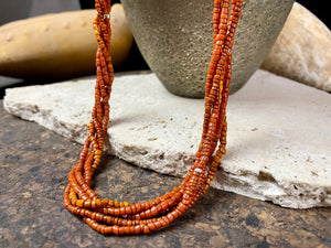 Our long tribal multistrand necklace is made with antique ceramic beads worn by the Bonda people of the Himalayas. This five strand red-brown-orange necklace is finished with a handmade sterling silver clasp and features sterling silver bead detailing. Measurements: 66 cm length