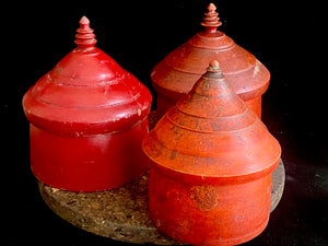 Large red lacquered tikka pot or tikka boxes. Hand carved from single hollowed out pieces of teak, these lidded pots traditionally hold the red vermillion (bindi) powder used for marking the forehead during Hindu ceremonies. They date to the early 1900s. Measurements: approximate diameter 12-14 cm, height 16-18 cm