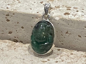 Hand carved from a single high quality translucent emerald and set in a silver surround with silver bail, this oval pendant features a beautifully detailed image of Ganesh.  Height including bail 3.1 cm, width 1.4 cm