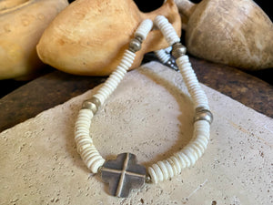 A mid-length white howlite and silver necklace crafted crafted from natural heshi cut beads, with a handmade sterling silver cross centrepiece and antique Indian silver beads. Finished with sterling silver ends and hook clasp. Total length 51.8 cm, pendant 2.5 cm diameter
