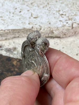 This amulet depicts Durga within the framework of the yoni leaf shape. High grade silver. Early 20th century or older. The double bail has an original wrap of cotton cord over it to protect it from further wear. Wear to the bail is evident but remains sturdy.  Measurements: height 5.5 cm including bail, width 3.4 cm