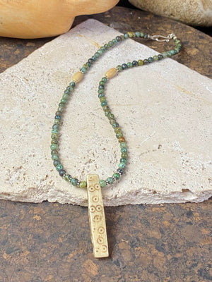 Tribal inspired necklace made from African jasper, highlighted with an antique Naga bone pendant and Kachin antique bone beads. Sterling silver findings and hook clasp. This unisex necklace is 45.5 cm (18") in length, pendant 5 cm (2") length.