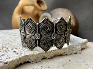A modern interpretation of an antique style of bracelet, this piece is hand crafted from sterling silver by Rajasthani silversmiths. Exquistely detailed, the oxidised finish shows off the workmanship beautifully. There is some room for movement in this cuff, and it is designed to fit an average sized wrist.  Measurements: Inside opening is 6.5 cm, with room for expansion or contraction