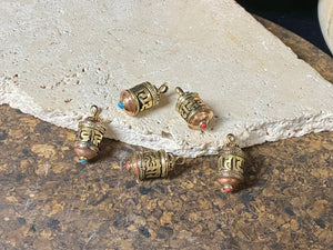 Miniature prayer wheel or prayer box designed to be worn as a pendant, a charm on a bracelet or added to a keyring. Brass and copper, containing a prayer scroll. Height 3 cm. Mantra is Om Mani Padme Hum, prayer to the Compassionate Buddha