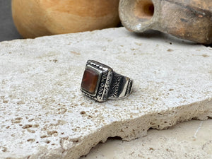 An elegant ring featuring a beautiful dark carnelian stone. The stone shows some wear commensurate with its age. Afghanistan, early to mid 20th century. Can be worn by either men or women. Measurements: Ring face 1.6 x 1.3 cm, inner diameter 18.5 mm | Size 8.5 | No 19