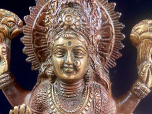 A statue of the goddess Laxmi (or Lakshmi), Hindu goddess of wealth and prosperity. Cast from solid brass, her features are exquisitely detailed, while her face, hands and feet are polished. Her right hand is raised in the gesture of protection and her left hand holds a pot symbolising abundance. Measurements: 19.8 cm height, width12 cm, depth 8.3 cm