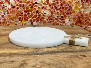 Our simple marble plate is designed for serving nibbles or for use as a cheeseboard. However, its simplicity means that it would also make a very nice plant or object stand. Hand carved in Rajasthan from white marble. A simple handle with hole for hanging completes the look. Measurements: length 29 cm, 21.5 cm disk diameter