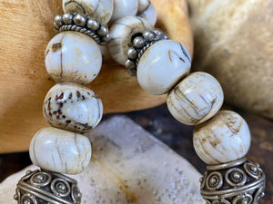 This statement choker necklace inspires Boho chic and features large antique Naga shell beads beads, vintage Indian silver beads and a handmade sterling silver hook. The central bead is an old piece consisting of hand wrapped silver over a wood frame. Length 48 cm
