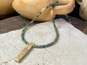 Tribal inspired necklace made from African jasper, highlighted with an antique Naga bone pendant and Kachin antique bone beads. Sterling silver findings and hook clasp. This unisex necklace is 45.5 cm (18") in length, pendant 5 cm (2") length.
