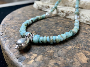 Light blue blue necklace of tumbled, facet cut graduated larimar, highlighted with Rajasthani silver beads and a beautiful central drop pendant. Finished with sterling silver findings and hook clasp. and a hook clasp. Measurements: 46 cm (18") length