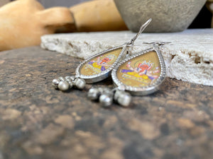 Exquisite miniature hand painted earrings featuring Ganesh seated, set within sterling silver frames, backed with decorated silver and set with a silver dangles bail at the base. Bought from the artist who painted them in India, then set into silver. Measurements: 6 cm (2.35") height including hooks or 2 cm at widest point