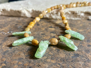 A polished pebble golden ocean jasper short necklace featuring spears of natural, unpolished green kyanite and sterling silver. Our necklace is finished with a sterling silver hook clasp and findings. Length 38 cm