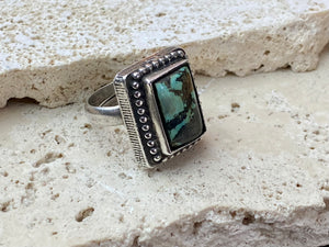 Silver tribal ring, set with a large antique Tibetan turquoise stone. This substantial heavy ring weighs almost 15 grams. Will suit either men or women. Afghanistan. Measurements: Ring face 2.2 x 2 cmInner diameter 17.5 mm | Size 7, however this is an adjustable ring that will fit any finger from size 6 to 8.