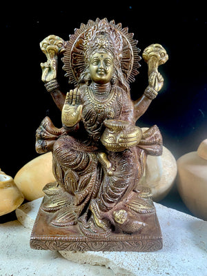 A statue of the goddess Laxmi (or Lakshmi), Hindu goddess of wealth and prosperity. Cast from solid brass, her features are exquisitely detailed, while her face, hands and feet are polished. Her right hand is raised in the gesture of protection and her left hand holds a pot symbolising abundance. Measurements: 19.8 cm height, width12 cm, depth 8.3 cm