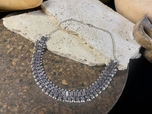 A classic Rajasthani style Indian necklace in white metal (non silver). Flattering to any neckline, it can be worn as a choker or a longer necklace by fastening the chain length to suit. It also be worn as an anklet by removing the chain altogether.  Beautiful without the sterling silver price tag. Measurements: 47.2 cm length with chain. Without chain 25.5 cm.