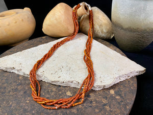 Our long tribal multistrand necklace is made with antique ceramic beads worn by the Bonda people of the Himalayas. This five strand red-brown-orange necklace is finished with a handmade sterling silver clasp and features sterling silver bead detailing. Measurements: 66 cm length
