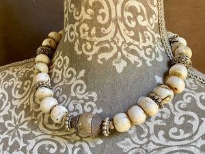 This statement choker necklace inspires Boho chic and features large antique Naga shell beads beads, vintage Indian silver beads and a handmade sterling silver hook. The central bead is an old piece consisting of hand wrapped silver over a wood frame. Length 48 cm