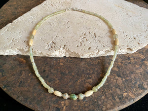This unique choker features beautiful vintage beads from the Kashgar collection - blue green turquoise centre bead, Ethiopian opal, Bone beads from Burma, Pale green chrysoprase beads, Green serpentine tube beads from Afghanistan and 925 sterling silver detailing and lobster clasp. Length 40.5 cm