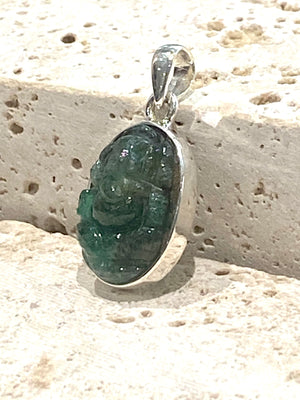 Hand carved from a single high quality translucent emerald and set in a silver surround with silver bail, this oval pendant features a beautifully detailed image of Ganesh.  Height including bail 3.1 cm, width 1.4 cm