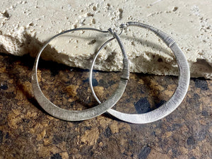 Beautiful hand beaten sterling silver hoops with wrapped silver wire detailing. Waziri, from Afghanistan. Measurements: outside diameter of hoop approximately 4.6 cm