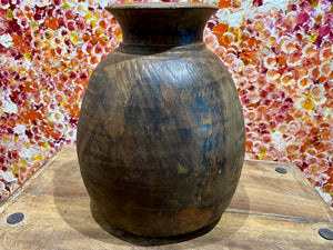 These gracefully shaped pots were used to store lassi, oil, milk, water and grain. This large example comes from northern India and is carved from solid hardwood, in this case most likely teak. Mid 20th century or earlier. slight decoration around the neck and mouth. Repair to the base. Measurements: diameter 22 cm, height 28 cm