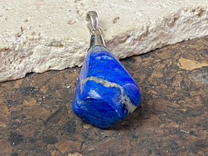 Freeform lapis lazuli top mounted pendant. The rich blue lapis originates from Afghanistan. Set in sterling silver with a generous bail to take a sizeable cord or chain. Height 5.5 cm