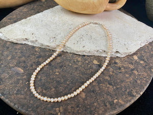 A simple pearl choker necklace, featuring champagne coloured off-round pearls, finished with sterling silver findings and clasp.  These are quality cultured freshwater pearls with a beautiful sheen and thick nacre finish.   Measurements: length 39.5 cm including clasp. Pearls are 4 mm diameter