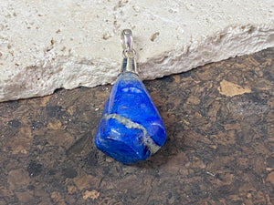 Freeform lapis lazuli top mounted pendant. The rich blue lapis originates from Afghanistan. Set in sterling silver with a generous bail to take a sizeable cord or chain. Height 5.5 cm